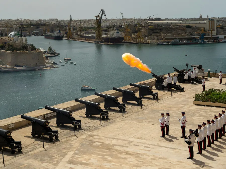 Ceremonial cannons on a Valletta bastion with a puff of fire over the harbour